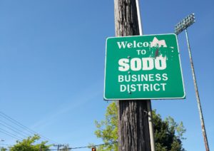 A sign reading "Welcome to SoDo Business District", in Seattle Washington.